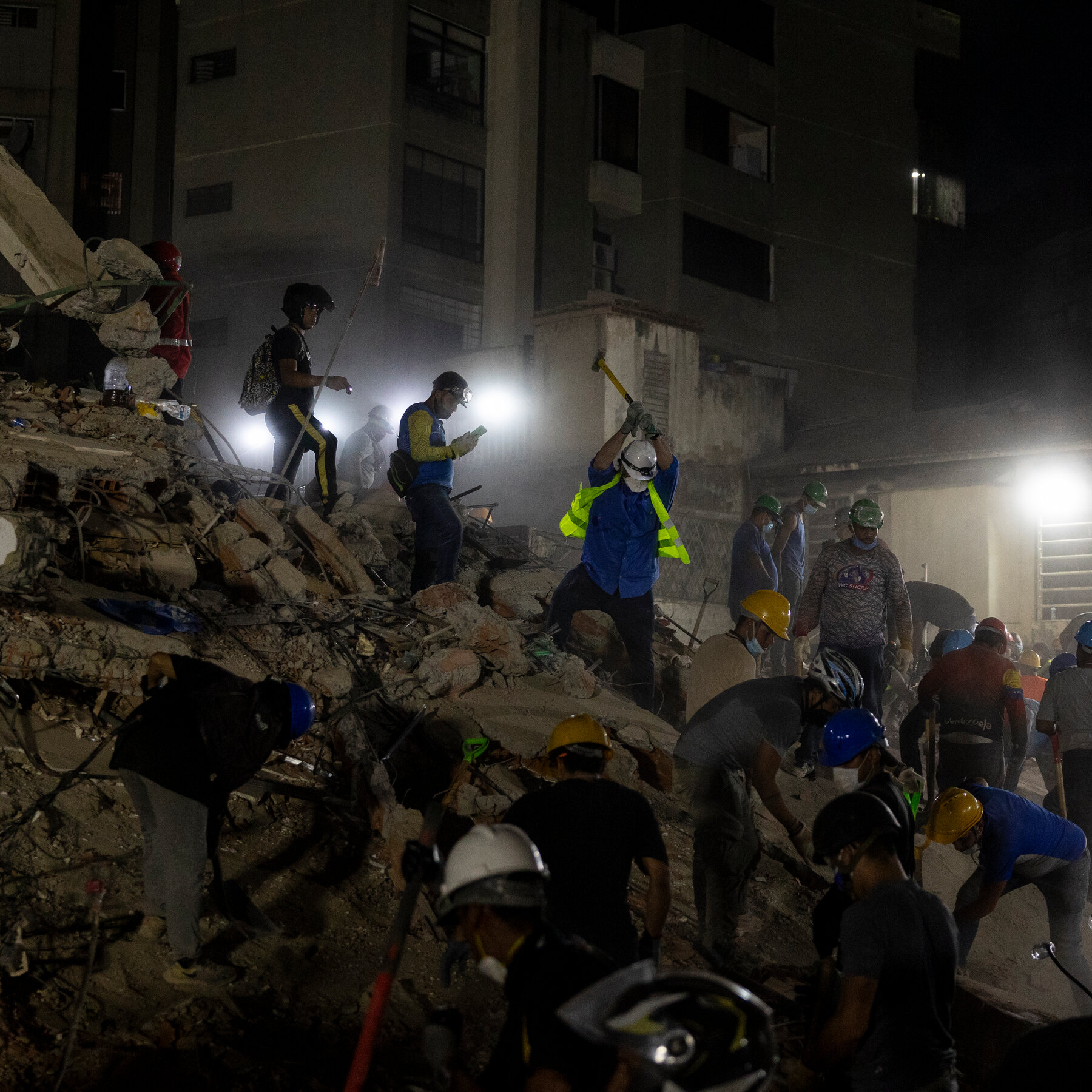 Volunteers in Caracas Neighborhood Dig for Survivors with Drills and Hammers